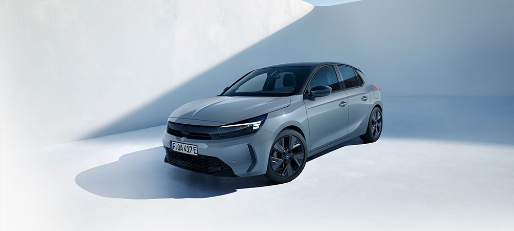 Grauer Opel Corsa, schr&auml;g von vorn fotografiert in heller Studioumgebung.